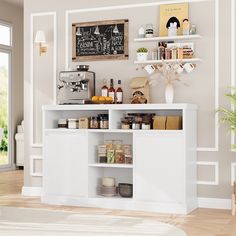 a kitchen with white cupboards and shelves filled with food, drinks and condiments