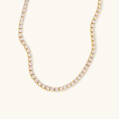 The Eternal Radiance Tennis Necklace shines with timeless elegance, featuring a row of dazzling diamond simulants set in 18K gold. This piece embodies the perfect balance of luxury and simplicity, making it ideal for special occasions or adding a touch of glamour to everyday wear. With its radiant sparkle and sleek design, this necklace is crafted to catch the light from every angle, ensuring you stand out with sophistication and grace. A must-have addition to any jewelry collection. Composition:Ethically sourced Stainless Steel-Plated 18k Gold and AAAAA Diamond Simulants.Water, Sweat, and Heat Resistant. (No discoloration, No Tarnishing).Hypoallergenic and skin-friendly.Comes in an eco-friendly package.Measurement:Length: 14 InchesWeight: 7.6 g Everyday Luxury Cubic Zirconia Tennis Necklace, Dazzling Cubic Zirconia Tennis Necklace For Everyday Luxury, Classic Tennis Necklace With Diamond Accents As A Gift, Timeless Cubic Zirconia Tennis Necklace With Prong Setting, Timeless Cubic Zirconia Tennis Necklace For Anniversary, Classic Crystal Tennis Necklace With Prong Setting, Classic Tennis Necklace In Diamond White Cubic Zirconia, Classic Crystal Tennis Necklace, Gold Crystal Round Cut Necklace