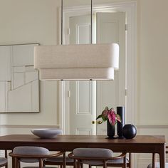 a dining room table with chairs and vases on it