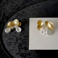 two pairs of earrings sitting on top of a piece of paper