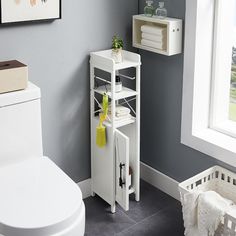 a white toilet sitting next to a shelf with towels on it's sides in a bathroom