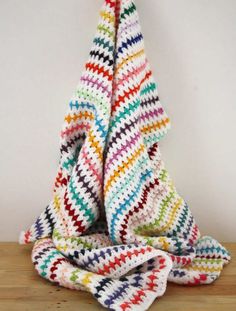 a crocheted christmas tree sitting on top of a wooden table