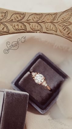 an engagement ring sits in a velvet box