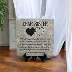 a sign that says dear sister with two hearts in the center on a wooden floor