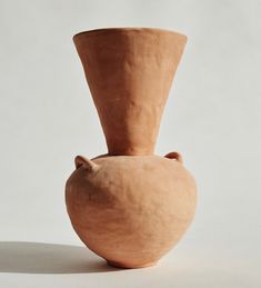 a clay vase sitting on top of a white table