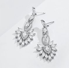 A delightfully unique pair of wedding earrings with an incredible sparkle. The flawlessly faceted cubic zirconia stones capture the light in a dazzling array of sparkles, while the delicate links add fluidity and motion. The earrings are rhodium plated for a bright finish which enhances the intricate detailing and conveys a modern take on old elegance. Length: 1.8" (approx. 4.6cm); Width: 0.8" (approx. 2.2cm); Weight: 11g. Hypoallergenic - lead, nickel and cadmium free. This exquisite design wil Diamond White Dazzling Chandelier Earrings With Sparkling Stones, Dazzling Diamond White Chandelier Earrings With Sparkling Stones, Diamond White Crystal Chandelier Earrings For Anniversary, Crystal Chandelier Earrings With Sparkling Stones For Anniversary, Anniversary Crystal Chandelier Earrings With Sparkling Stones, Elegant White Gold Crystal Bridal Earrings, Dazzling Cubic Zirconia Chandelier Earrings For Anniversary, Diamond White Cubic Zirconia Chandelier Earrings With Sparkling Stones, Cubic Zirconia Sparkling Stones Drop Earrings