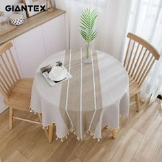 the table is set with two chairs and a white plate on it, next to a potted plant