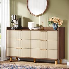 a dresser with a mirror and vase on top of it in front of a window