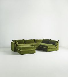 a large green couch sitting on top of a white floor