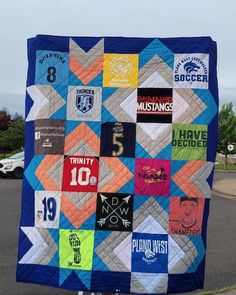 a man is holding up a quilt made to look like it has many different patches on it