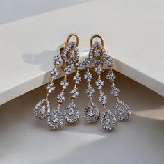 Add a touch of glamour to your look with our Glitz CZ Sparkle Earrings, crafted passionately in silver and adorned with unique 5A lab-created diamonds by CZ. These luxurious stones create a vivid and high-quality appearance, giving the earrings a real diamond feel. Finished with 18kt gold accents and a highly-reflective rhodium polish, these earrings are not only dazzling but also durable, ensuring they maintain their sparkle for years to come. Finish: Yellow Gold Plating Material: Silver, Alloy Dazzling Diamond White Crystal Earrings With Sparkling Stones, Dazzling Diamond White Earrings With Sparkling Stones, Dazzling Chandelier Earrings With Diamond Accents, Dazzling Diamond White Crystal Earrings, Diamond White Dazzling Chandelier Earrings With Sparkling Stones, Dazzling Diamond White Chandelier Earrings With Sparkling Stones, Dazzling Cubic Zirconia Chandelier Earrings For Anniversary, Elegant Diamond Crystal Earrings For Gift, Glamorous Cubic Zirconia Clip-on Earrings For Anniversary