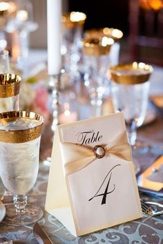 a table set up with place cards and wine glasses