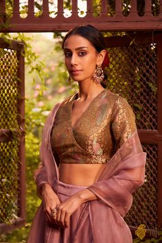 "Lakshmi\nA regal set\u00a0with old-world grandeur,\u00a0combined with modern-day effortlessness. A glorious full-ghera silken lehenga skirt, paired with an exquisitely handwoven satin tissue brocade blouse. Set against\u00a0the soft, fleeting romance of\u00a0intricate floral hand-embroidery on pure gossamer organza.\n\u00a0\n\n\n\n Color\u00a0-\u00a0A\u00a0blouse in a beautifully shimmering\u00a0shade of\u00a0Olive Green, skirt and odhani in a Dusty Pink\n\n Fabric\u00a0- Pure Satin Silk Tissue Brocade Handwoven Blouse,\u00a0Pure Silk Skirt and Pure Silk Organza Odhani\n\n Speciality\u00a0-\u00a0An extraordinary visual and an effortless silhouette. Beautifully handwoven in lush satin silk tissue with multicoloured tanchoi meenakari, glorious peacocks adorn the\u00a0statement angarakha-sty Banarasi Saree Blouse, Banarasi Blouse, Brocade Blouse Designs, Brocade Lehenga, Brocade Saree, Simple Lehenga, Latest Model Blouse Designs, Traditional Dresses Designs, Silk Saree Blouse Designs