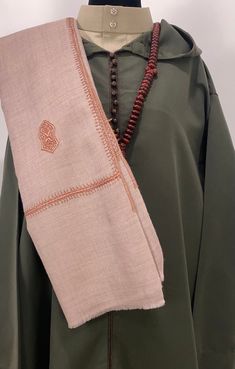 Introducing the Nur Sandala Shawl, a stunning piece that features 25 sacred Sandala patterns meticulously hand-embroidered across the fabric. The Nur Shawl is 12-inch wider than our popular Zayn Shawl, offering even more elegance and versatility. Crafted from premium soft wool, this shawl is woven in Kashmir using traditional mechanized looms, producing five to six scarves daily. Each piece is hand-dyed, and the intricate embroidery is done by skilled farmer-artisans in the villages, utilizing t Traditional Cream Pashmina Dupatta, Transitional Beige Traditional Wear, Traditional Cream Pashmina Shawl For Festive Occasions, Traditional Cream Pashmina Shawl, Traditional Brown Pashmina Shawl With Patterns, Traditional Embroidered Pashmina Shawl For Wedding, Traditional Wedding Pashmina Shawl With Embroidered Border, Beige Traditional Wear With Embroidered Border, Transitional Festive Embroidered Pashmina Shawl