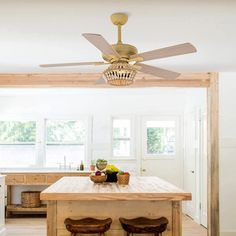 the ceiling fan is hanging from the ceiling in this kitchen with wooden table and stools