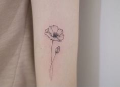 a single flower tattoo on the arm