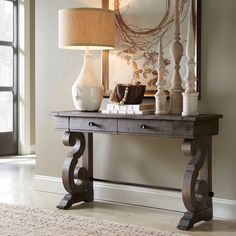 a table with a lamp on top of it next to a mirror and door way