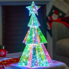 a brightly lit christmas tree sitting on top of a table