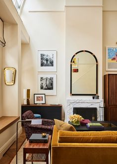 a living room filled with furniture and a fire place in front of a mirror on the wall