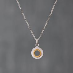 Brushed Silver and Gold Vermeil Open Circle Pendant Necklace.  This minimalist pendant is handmade in sterling silver with gold vermeil contrast detail and a brushed texture finish.  Dimensions (approx): * Pendant height: 2.2cm including bail * Pendant width: 1.5cm  * Chain: 16" - 18"  Materials: * Sterling Silver * Gold Vermeil  Matching earrings:  https://www.etsy.com/uk/listing/826071058 Beyond Biasa creates unique jewellery that is inspired by antique and tribal designs from around the globe Metal Pendant Necklace, Minimalist Pendant, Circle Pendant Necklace, Necklace Minimalist, Black Rhodium, Circle Pendant, Silver And Gold, Matching Earrings, Gold Vermeil