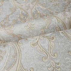 a close up view of the fabric with gold and silver paisley pattern on it's surface