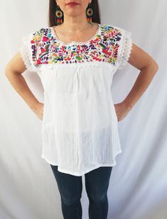 Beautiful blouse made by hand in Chiapas, Mexico creating fashion and art. This is a beautiful blouse with colorful flowers and short sleeve. Very comfortable, Goes great with jeans, leggings, skirt, shorts... Each piece is unique and handmade with dedication and taking care of every detail achieving the best quality in our products, which is why it makes it beautiful and unique each of the embroidered flowers. You can buy the blouse with the earrings Colors and flowers may vary depending on the White Embroidered Short Sleeve Top, White Floral Embroidered Short Sleeve Top, White Floral Embroidery Short Sleeve Top, White Embroidered Beach Shirt, White Short Sleeve Top With Embroidered Hem, White Embroidered Hem Top With Short Sleeves, Fitted Short Sleeve Top With Embroidered Hem, Fitted Short Sleeve Embroidered Top, Summer Embroidered Hem Short Sleeve Tops