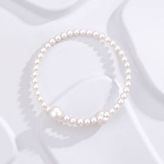 Experience elegance redefined with our "Eternal Embrace" White Freshwater Pearl Bracelet. Two large pearls gracefully frame the open closure, forming a captivating large circle that symbolizes unity and endless beauty. The design's simplicity accentuates the pearls' natural allure, making it a versatile piece suitable for both casual and formal occasions. A classic with a contemporary twist, this bracelet is a timeless addition to any jewelry collection. Pearl size 5-7mm Note: Our jewelry is han Adjustable Pearl Bracelet With Pearl Pendant, Adjustable Pearl Bracelets With Pearl Pendant, Adjustable Bracelet With Pearl Pendant, Gold Pearl Bracelet With Pearl Chain, Elegant Adjustable Bracelet With Pearl Pendant, Formal Pearl Bracelet With Pearl Charm, Elegant Adjustable Bracelets With Pearl Pendant, White Pearl Ring With Pearl Chain, Classic Pearl Charm Bangle Bracelet