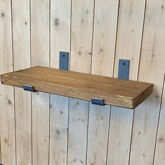 a wooden shelf with two metal brackets on it