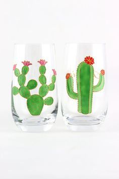 two wine glasses with cactus designs on the side and one has a red flower in it