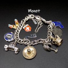 "*Description: This is a great Monet textured silver tone double chain, buckle closure charm bracelet with a safety chain from the 1970s. The Monet bracelet is adorned with ten charms, added by the original owner. Nine of the ten charms tested silver and several tested 10K gold wash. Here is a list of the world travel charms: 1. Maui (stamped STERLING), 2. Kauai (stamped STERLING), 3. Crown (tested silver), 4. Palm Tree ( stamped B-Ster), 5. Sombrero \"Mexico\" (tested silver), 6. 76, 7. Antique Retro Metal Charms Jewelry, Retro Metal Bracelets With Charms, Retro Metal Bracelet With Vintage Charm, Retro Metal Bracelets With Vintage Charm, Retro Silver Jewelry With Charms, Retro Silver Metal Charm Bracelet, Collectible Vintage Charm Metal Bracelet, Vintage Metal Charm Bracelet, Vintage Jubilee Charm Bracelet Collectible