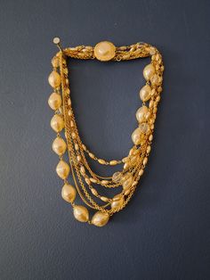 "Absolutely stunning large faux pearl and gold tone statement necklace.  Multi strand beaded necklace. The gold metal and faux pearls are vibrant and shiny.  Clear resin/plastic beads, plain gold chains and faux pearl beads adorn this gorgeous necklace.  Clasp is in great condition and closes/opens easily.  A great necklace to add to many different style outfits! Modern twist on your traditional pearl necklaces. Clean and ready to wear! Measurements are approximate: longest chain strand-10.5\" * Multi Strand Beaded Necklace, Necklace Clasp, Pearl Necklace Vintage, Gold Statement Necklace, Pearl Necklaces, Costume Jewelry Necklaces, Faux Pearl Necklace, Clear Resin, Necklace Vintage