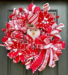 a red and white wreath with a snowman on it