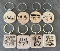 six wooden key chains with different sayings on them