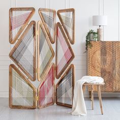 a room divider made out of rattan and woven material with a white tablecloth on the floor