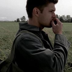 a man talking on a cell phone in a field