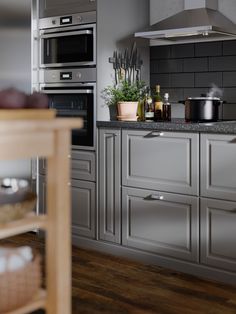 a modern kitchen with stainless steel appliances and wood flooring is pictured in this image