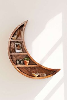 a wooden moon shelf with books and pictures on it