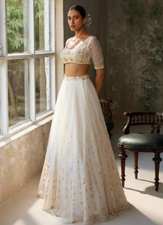 Embrace timeless elegance with the exquisite Ivory Embroidered Lehenga Set, crafted from pure silk organza. The full-length ivory lehenga showcases intricate hand-embroidery, adding a touch of opulence and tradition to the ensemble. Delicate motifs dance across the ethereal fabric, shimmering subtly in the light. Paired with matching half sleeved blouse features meticulous hand-embroidery, enhancing its luxurious appeal. A beautifully completed dupatta with hand-embroidered borders and motifs th Off White Wedding Choli With Cutdana, Off White Cutdana Choli For Wedding, Festive Floor-length Cream Choli, Wedding Lehenga In Off White With Cutdana, Cream Floor-length Lehenga With Cutdana, Elegant Off-white Choli With Zari Work, Off White Floor-length Sharara With Intricate Embroidery, Elegant Off White Lehenga For Diwali, Elegant Off-white Lehenga For Diwali