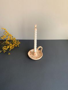 a white candle sitting on top of a table