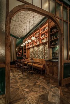 an arched doorway leads into a dining room with wood paneling and green walls on the other side