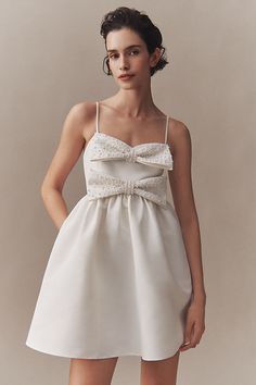 The Sachin & Babi Sloane Mini Dress features two layers of dimensional, feminine bows, pearl embellishments, and a charmingly voluminous skirt. The flirty, mini silhouette is finished with delicate spaghetti straps and pleated details - fit for a storybook romance. | Sloane Taffeta Pearl Double-Bow Pleated Mini Dress by Sachin & Babi in White, Women's, Size: Medium, Polyester at Anthropologie Feminine Mini Dress With Bow Tie Back For Wedding, Feminine Bow Tie Back Mini Dress For Wedding, Chic Wedding Dress With Bow Tie Back, Evening Organza Dress With Bow, Elegant Mini Dress With Bow Tie Back For Bridesmaid, Spring Wedding Mini Dress With Bow Tie Back, Chic Mini Wedding Dress With Detachable Bow, Chic Mini Dress With Bow Tie Back For Wedding, A-line Mini Dress With Bow For Wedding