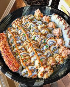 a platter filled with lots of different types of sushi and other food items