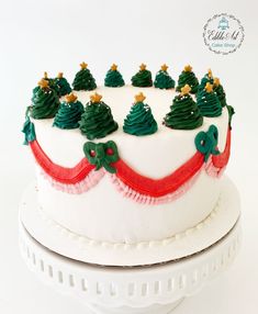 a white cake decorated with green and red decorations