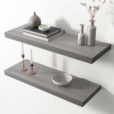 two floating shelves with candles and vases on them