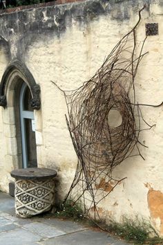 an old building with vines growing on the side and a small potted plant next to it