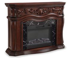 an antique style fireplace with marble surrounds and carvings on the mantel, shown in dark wood