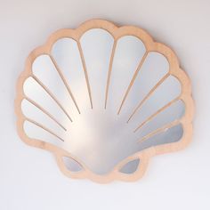 a mirror that is on the wall with a shell shaped design in it's center