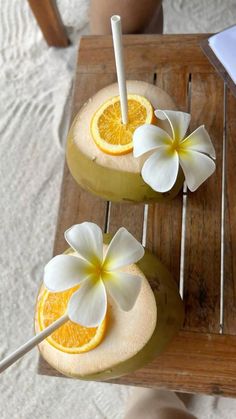 two oranges with flowers on them sitting on a table