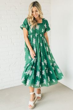 Be the belle of the ball in the Elena Embroidered Bubble Sleeve Dress! With a square neck and playful bubble sleeves, this dress will have you feeling cute and flirty. Perfect for any occasion, dress it up or down for a look that is uniquely you. (Note: Bubble sleeves may cause spontaneous twirling!) 80% Polyester 20% Tencel Square-Neck - Unique Style Straight Hem - Even Fit Unlined - Lightweight, Opaque Mid-Length - Breezy and cool Empire Waist - Bump Friendly! SIZE GUIDE & MEASUREMENTS: Model Cute Puff Sleeve Dress With Ruffles And Square Neck, Modest Floral Print Dress With Puff Sleeves, Green Puff Sleeve Dress With Ruffles, Party Dress With Smocked Bodice And Short Sleeves, Green Puff Sleeve Maxi Dress For Summer, Green Dress With Puff Gathered Sleeves, Flowy Puff Sleeve Dress With Square Neck For Party, Modest Fitted Puff Sleeve Summer Dress, Cute Square Neck Dress With Gathered Sleeves