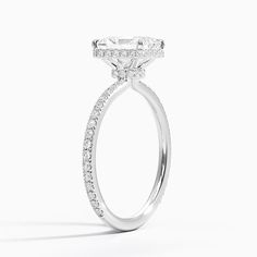 a white gold ring with diamonds on the sides and an oval shaped diamond in the center